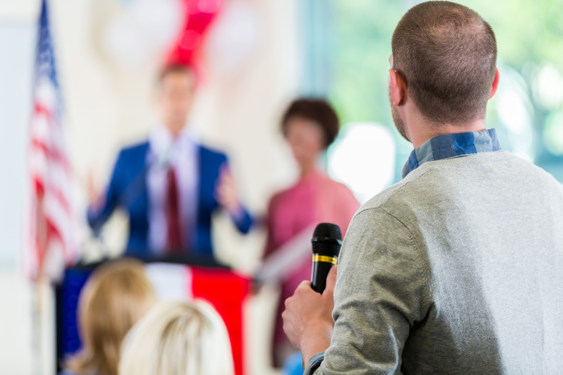 Man asking questions during political town hall meeting